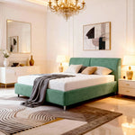 Modern bedroom with a green bed, chandelier, and abstract art.