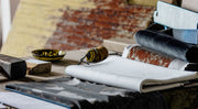 Upholstery fabric swatches and traditional tools on a workshop bench.