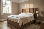 Compact London flat bedroom with a taupe upholstered ottoman storage bed, white bedding and morning light through a sash window