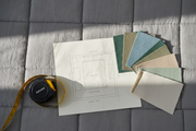 Overhead diagram-style photo of a double bed with a tape measure showing recommended walking clearance on both sides.