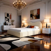 Modern bedroom with a chandelier, bed, and abstract art on the walls.